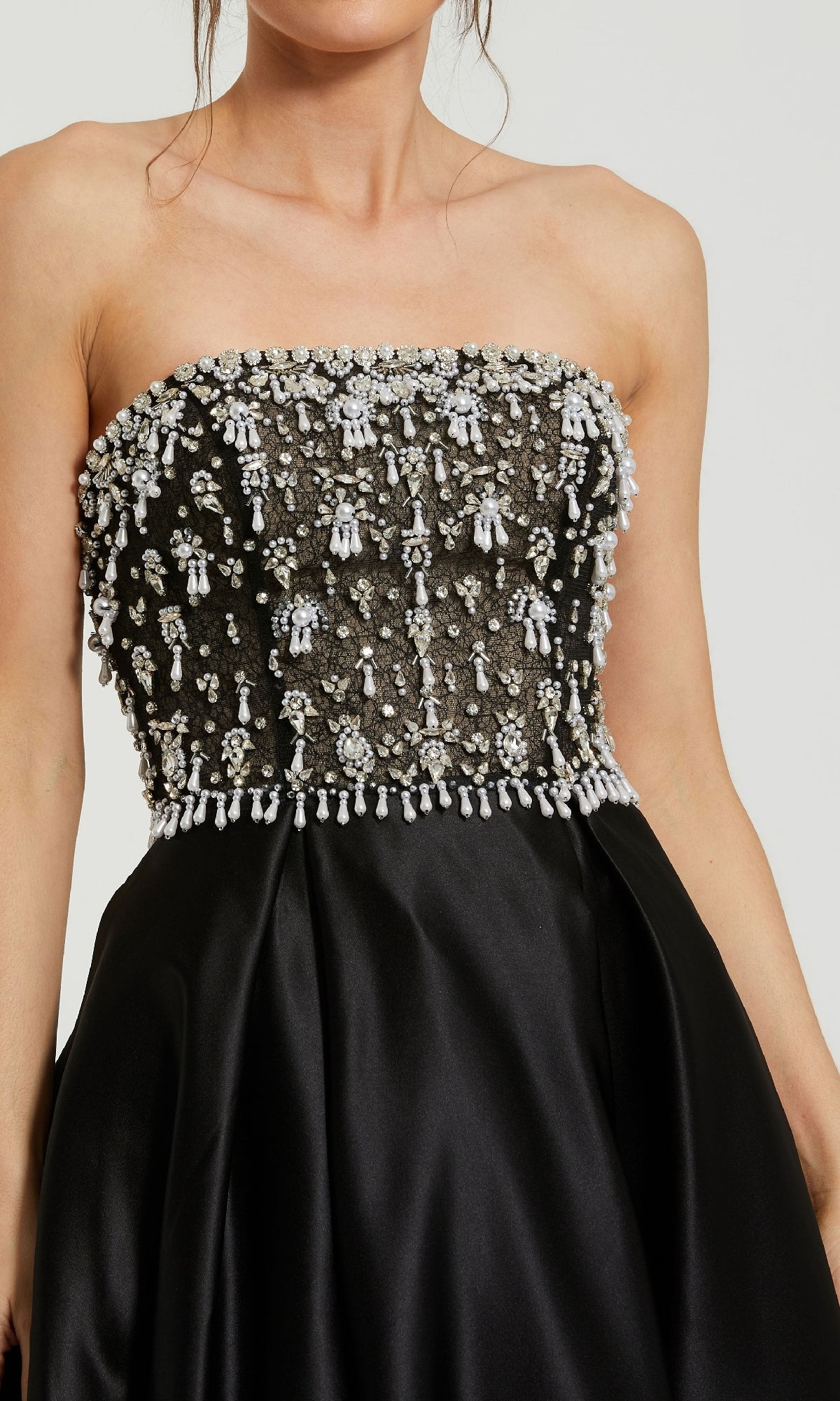Woman wearing the Strapless Black Satin Prom Gown: Mac Duggal 2225, featuring a long silhouette and embellished beaded bodice for elegant prom style.